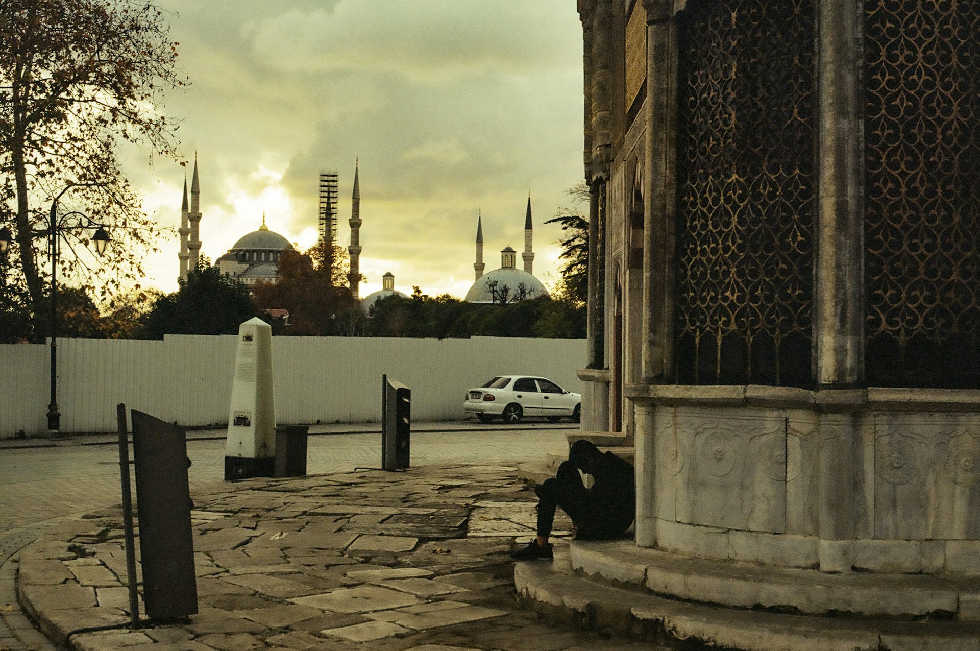 a person sitting on the ground next to a building